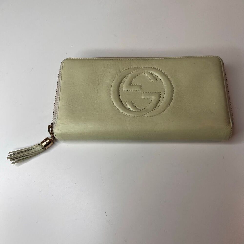 Gucci Soho leather zip-around wallet featuring an embossed Interlocking G logo a